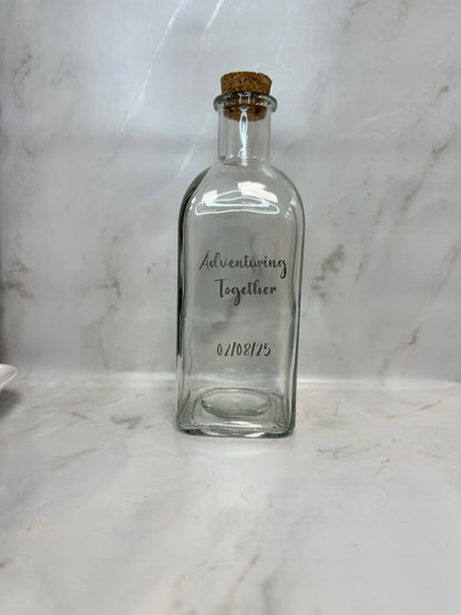 Clear glass bottle with cork on a marble surface